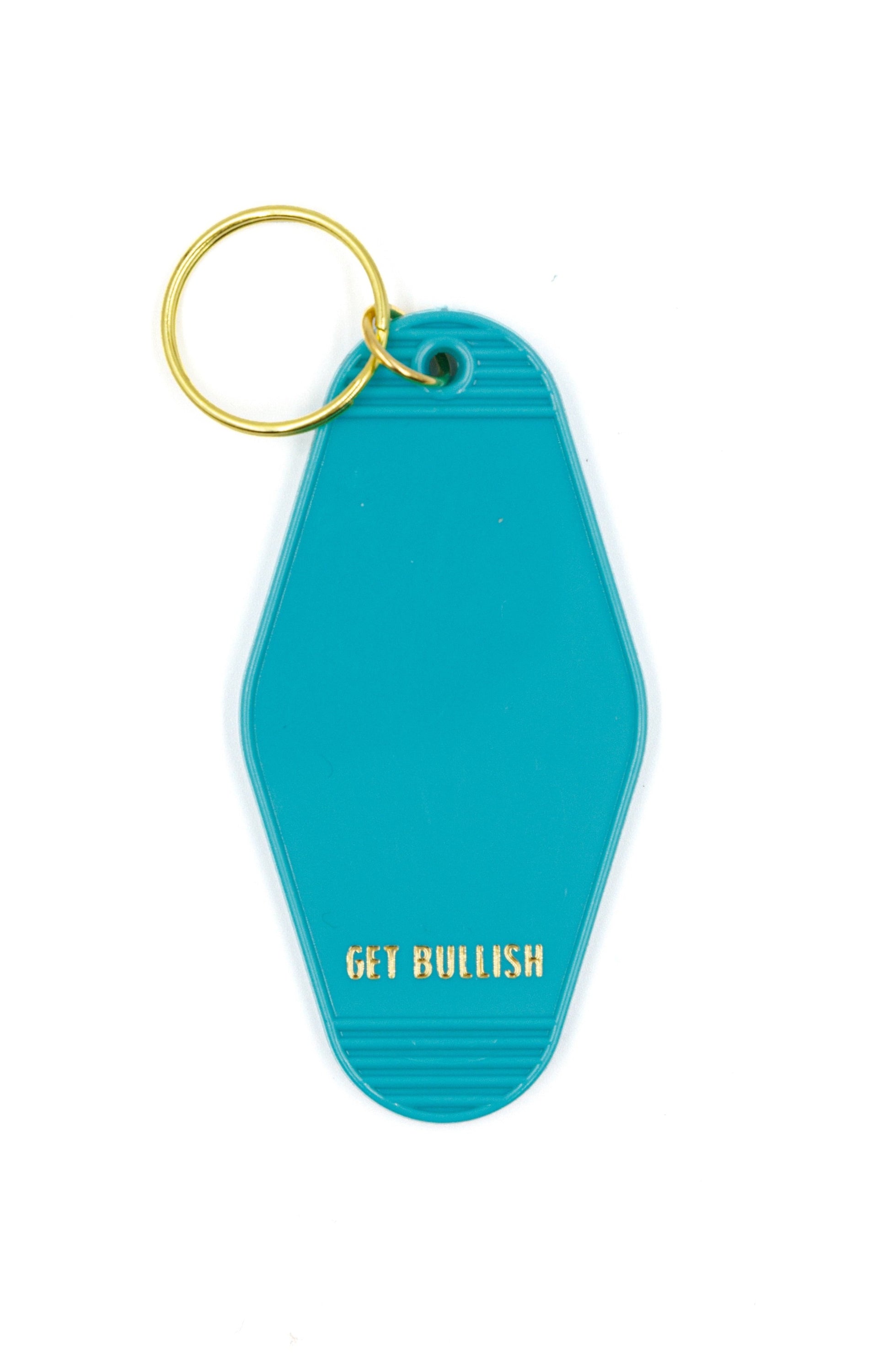 Aqua blue motel keychain with gold lettering saying 'OMG I DGAF', featuring a brass split ring.